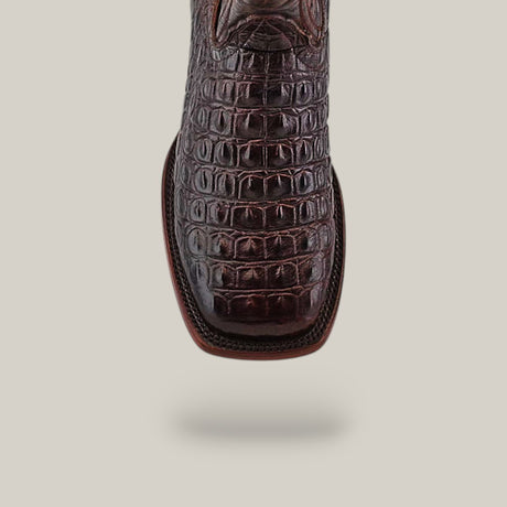 Close-up of the Alligatoar Horn Back Print Brown boot with a square toe and crocodile-patterned leather finish, set against a plain beige background.
