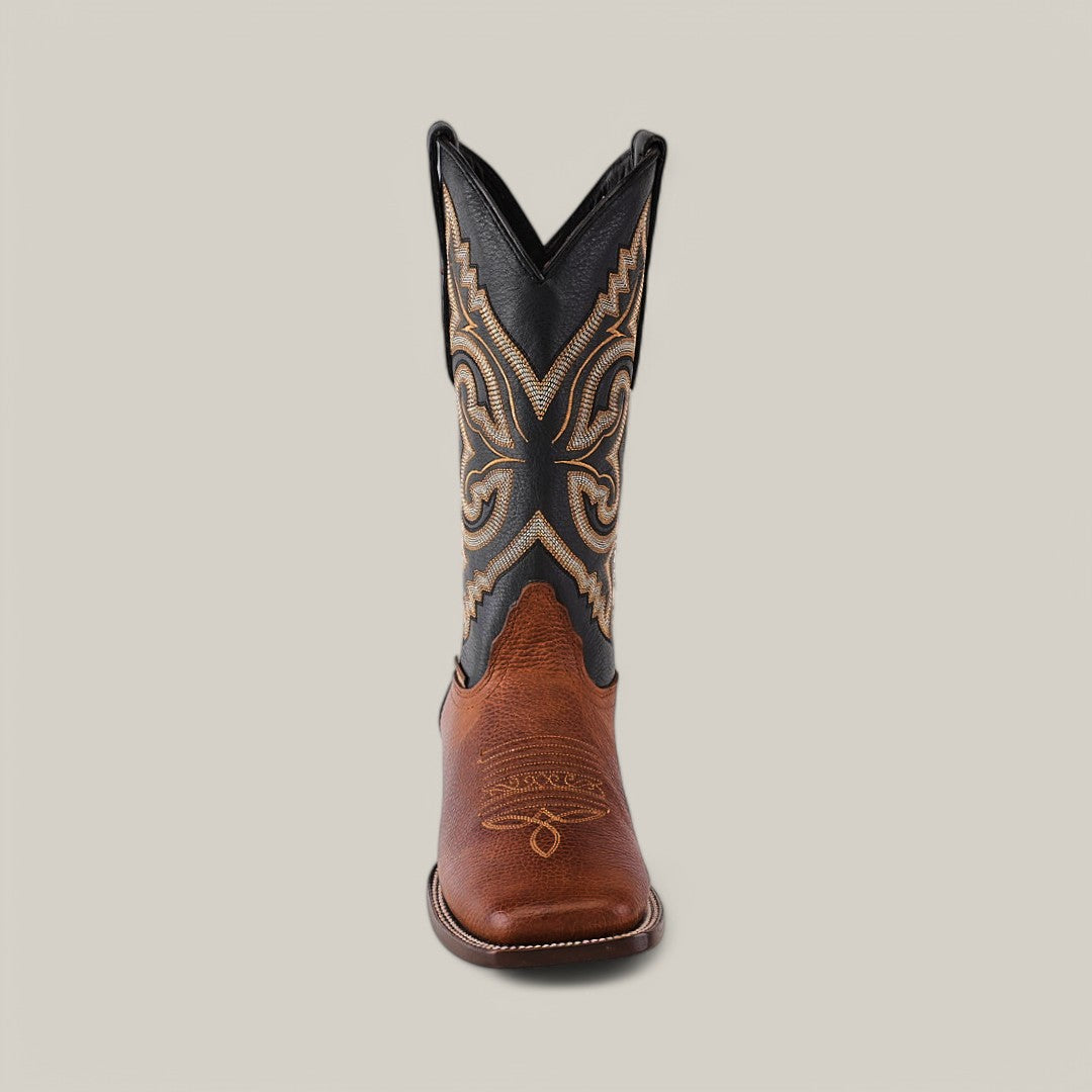The Grisly Tan - Square Toe boot, made from premium leather, features a brown foot and tall black shaft with intricate tan swirling embroidery, embodying Western style against a neutral backdrop.