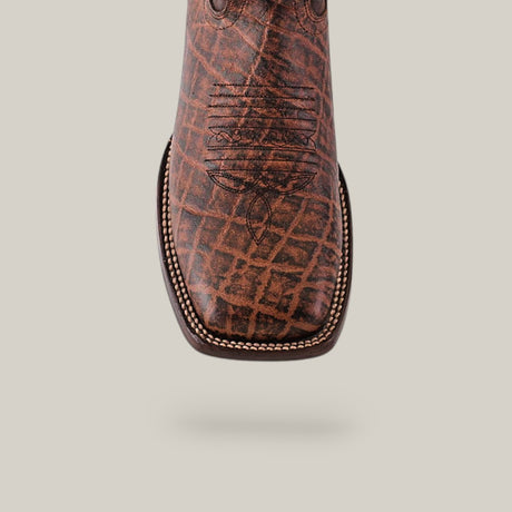 Close-up of the Mamut Grimm Brown - Square Toe cowboy boot featuring premium leather, a detailed stitched design on top, and a textured pattern with contrasting stitching along the edge against a neutral background.