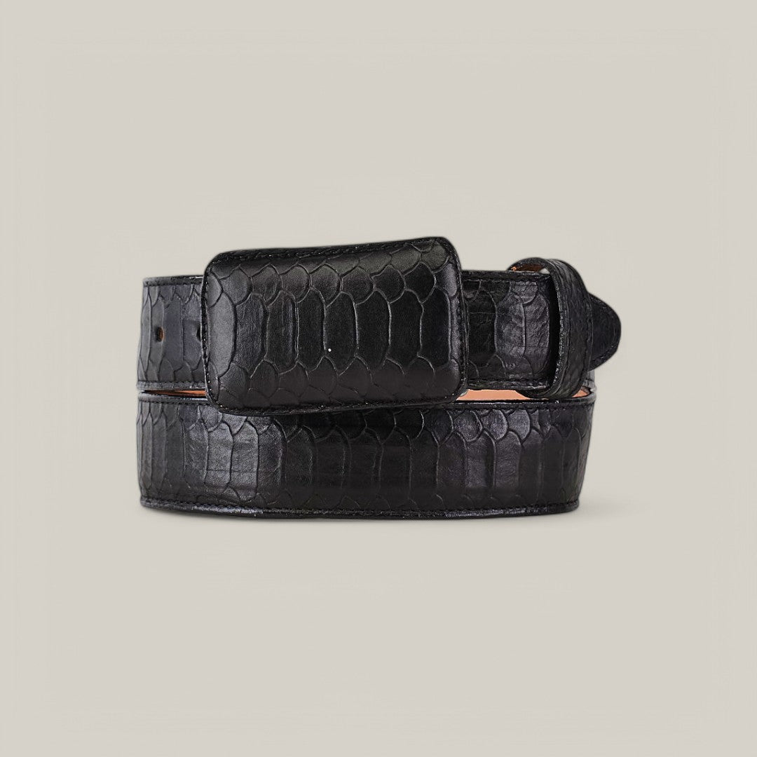 The Python Print Black - Cowboy Buckle is elegantly coiled on a light gray background, showcasing its sleek, polished finish with a reptile skin pattern and visible buckle that enhance its rugged charm and stylish allure.