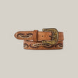 The Corella Fawn Belt - Texas Buckle is a brown leather belt embroidered with intricate floral designs and a metal buckle featuring engraved details. This elegant womens accessory is rolled to highlight its craftsmanship, ideal for those seeking sophisticated belts.