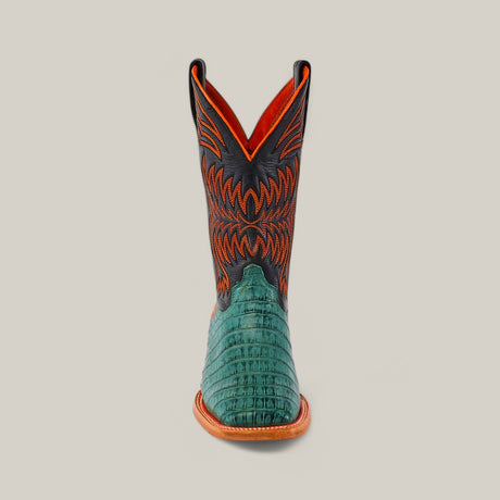 The front view of the Exotic Caiman Belly Tail - Green - Square Toe boots showcases a green, alligator-like textured lower section, paired with an orange and black upper featuring intricate stitching and a tan sole, against a plain background.