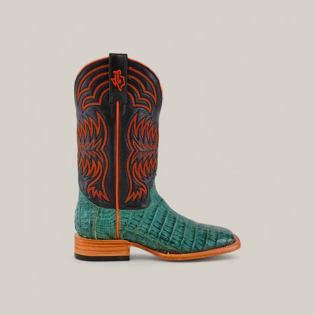 The Exotic Caiman Belly Tail cowboy boot, featuring a teal alligator skin lower from premium caiman leather and a black shaft with red stitching, showcases a wooden heel against a neutral background.