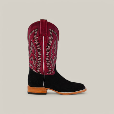 A single Black Suede - Platinum square-toe cowboy boot has a black lower section and burgundy upper shaft with intricate pink and white stitching, set against a plain gray background. It features a wooden sole and heel.