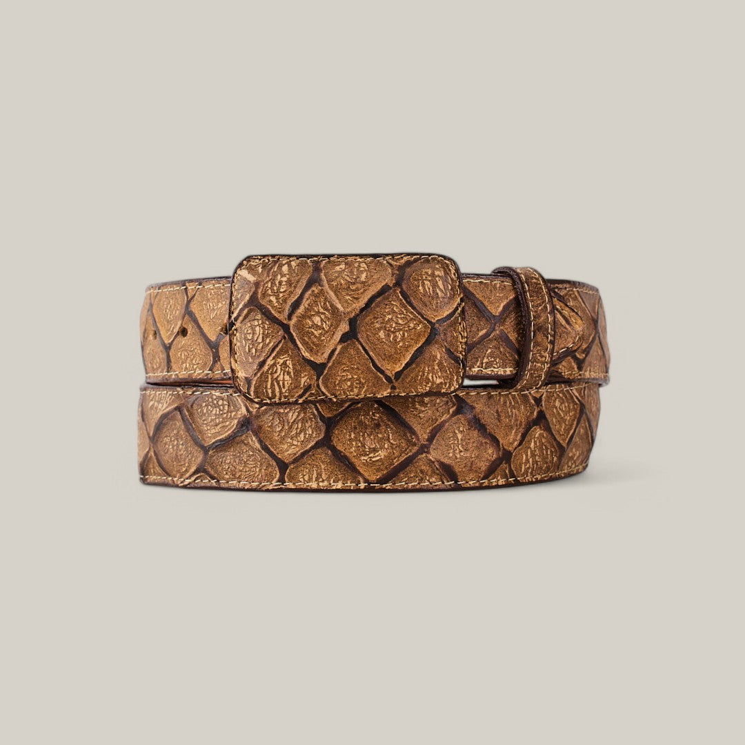 The Pirarucu Print Orix belt, featuring a cowboy buckle and crafted from exotic fish-scale-patterned brown leather, is coiled against a plain light gray background.