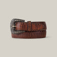 The Python Print Brown - Texas Buckle is a belt with an embossed scale pattern and intricate silver buckle, coiled with the tip through it, set against a gray background for both fashion and function.