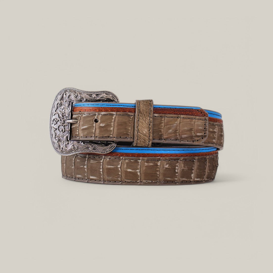 The Exotic Caiman - Platinum Buckle - Gray Belt features an elegant coiled design with a large, intricately engraved platinum buckle. Blue and red trims add flair against the light gray, making it a true luxury accessory.