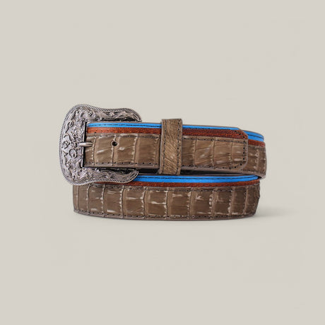 The Exotic Caiman - Platinum Buckle - Gray Belt features an elegant coiled design with a large, intricately engraved platinum buckle. Blue and red trims add flair against the light gray, making it a true luxury accessory.
