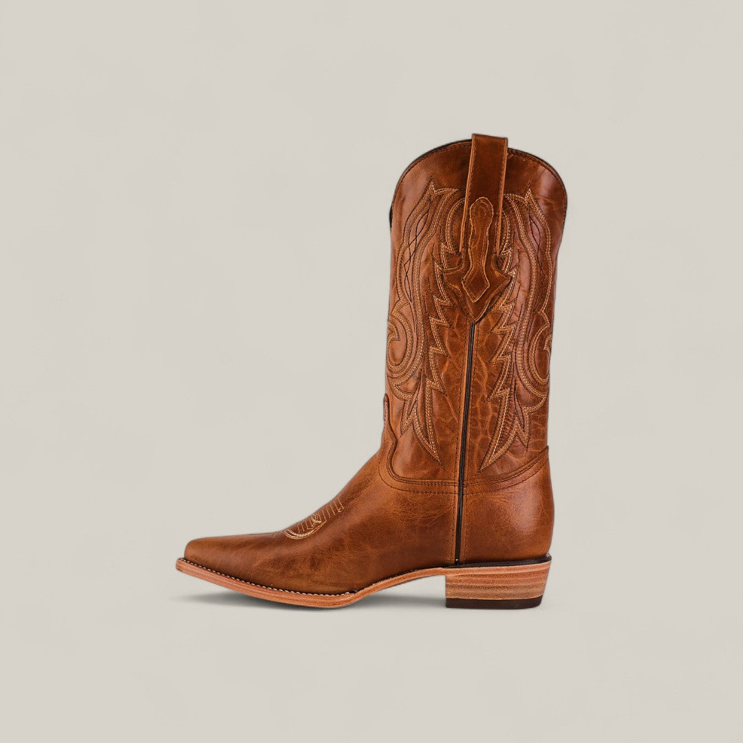 The Fresno - Fawn - Snip Toe boot, crafted from premium brown leather with decorative stitching, a pointed toe, and stacked heel, is displayed against a light beige background, highlighting its quality craftsmanship.