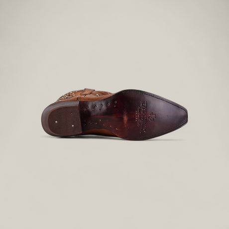 The Dolly - Brown - Snip Toe boot is shown from the bottom, featuring a pointed snip toe, decorative stitching, wooden heel, and visible maker’s logo on the sole against a plain light background.