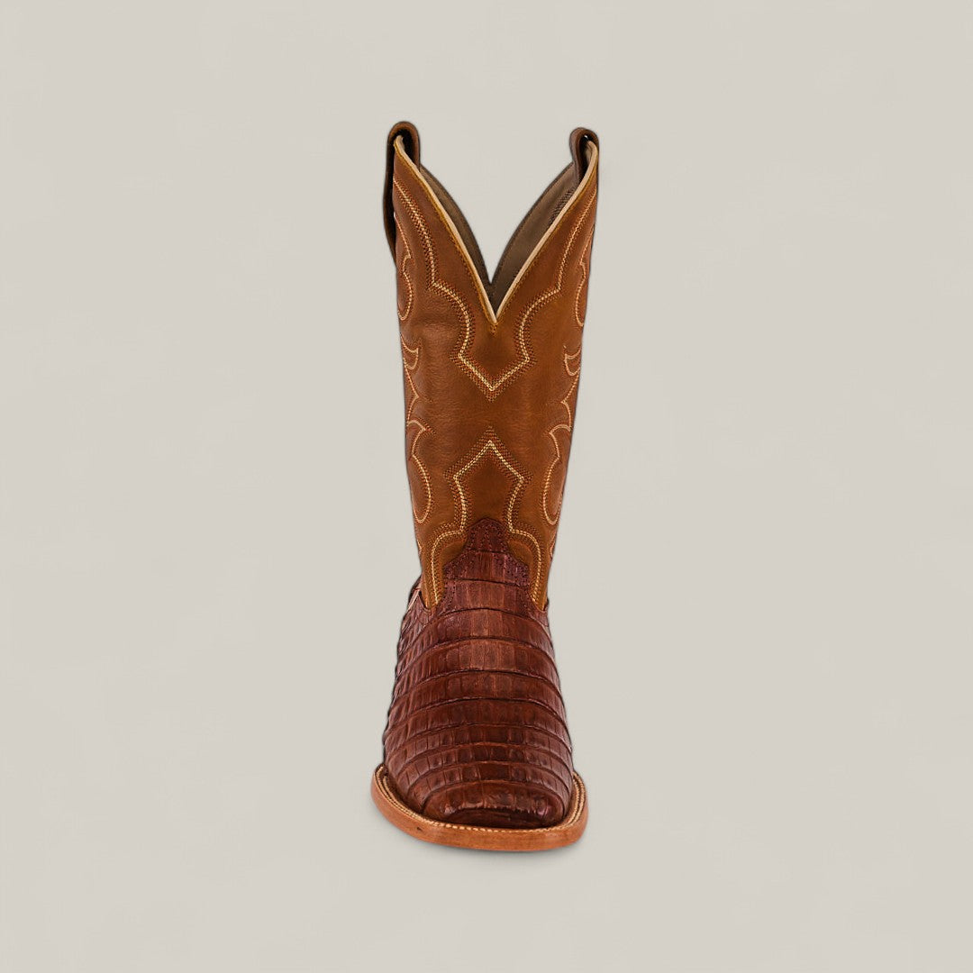 The Exotic Caiman Belly Tail - Brandy - Square Toe cowboy boot features decorative shaft stitching and a textured, dark Caiman Belly foot, displayed from the front on a plain, light background.