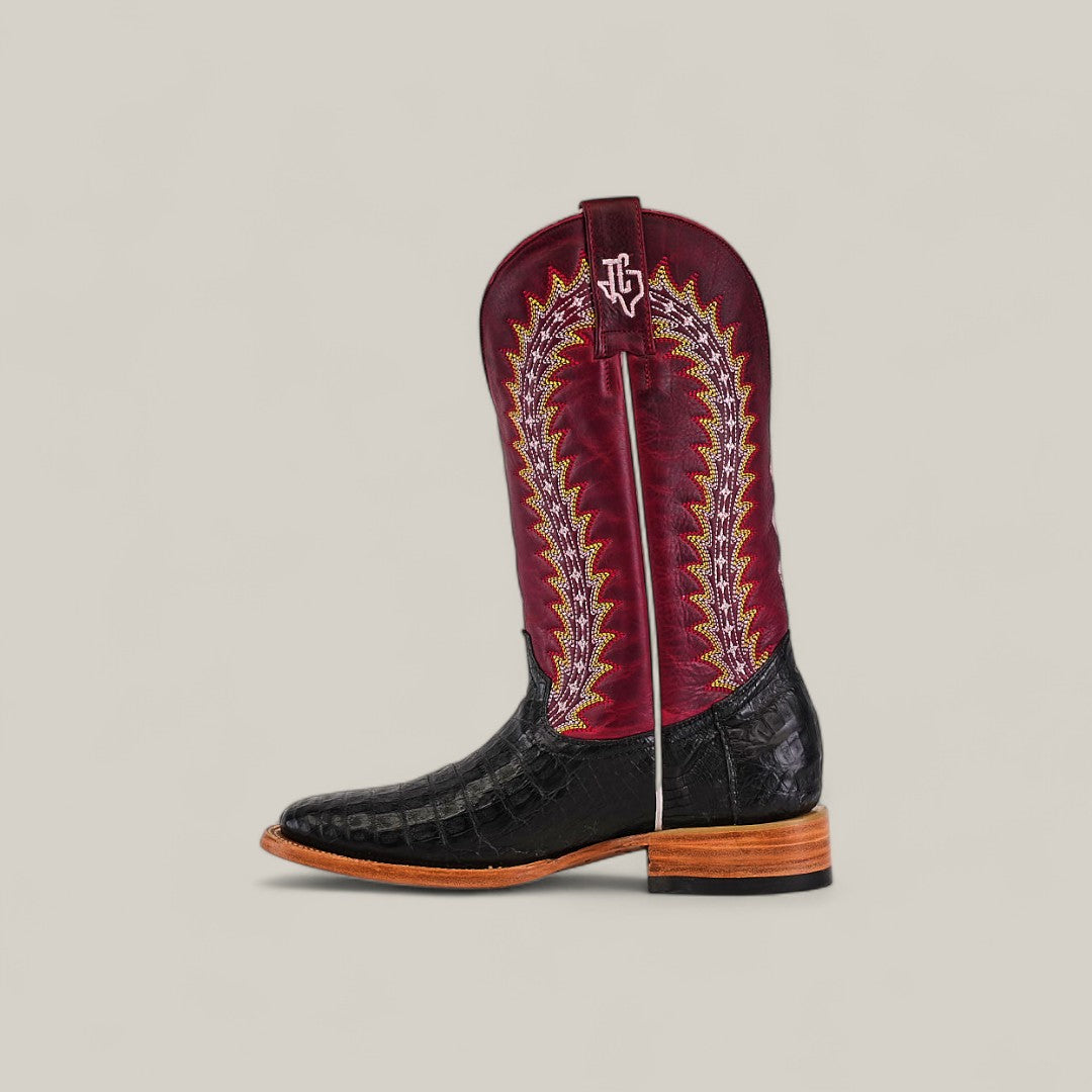 The Exotic Caiman Horn Back – Black – Square Toe from the Platinum Collection features a black textured foot, tall red shaft with yellow and white stitching, white pull strap, brown wooden sole, and a square toe design.