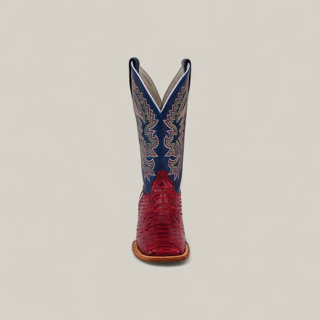The Exotic Python - Ruby / Blue - Square Toe boot is shown front-facing, with a red textured lower and blue upper shaft featuring white stitching, against a plain beige background. From the Platinum Collection.