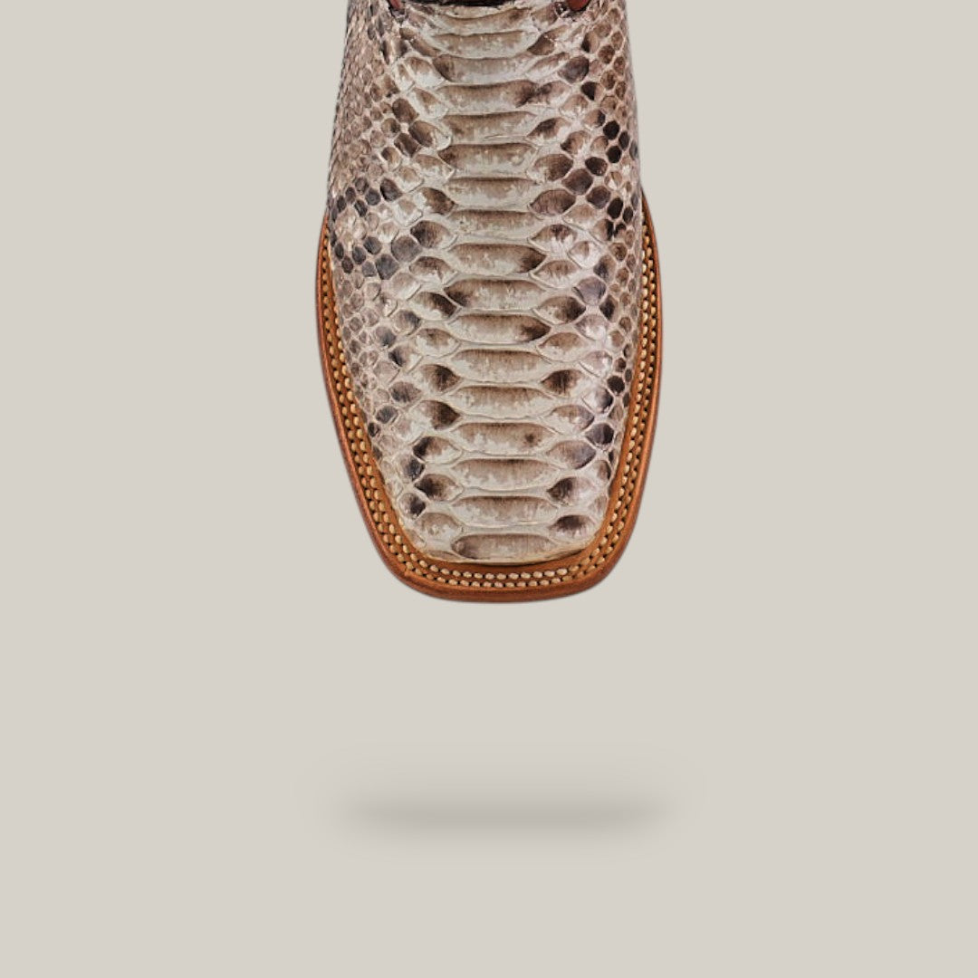 Close-up of the Exotic Python - Natural - Square Toe boot, featuring textured snakeskin leather with detailed scales and a stitched brown leather welt, set against a light background—a stylish piece from the Platinum Collection.