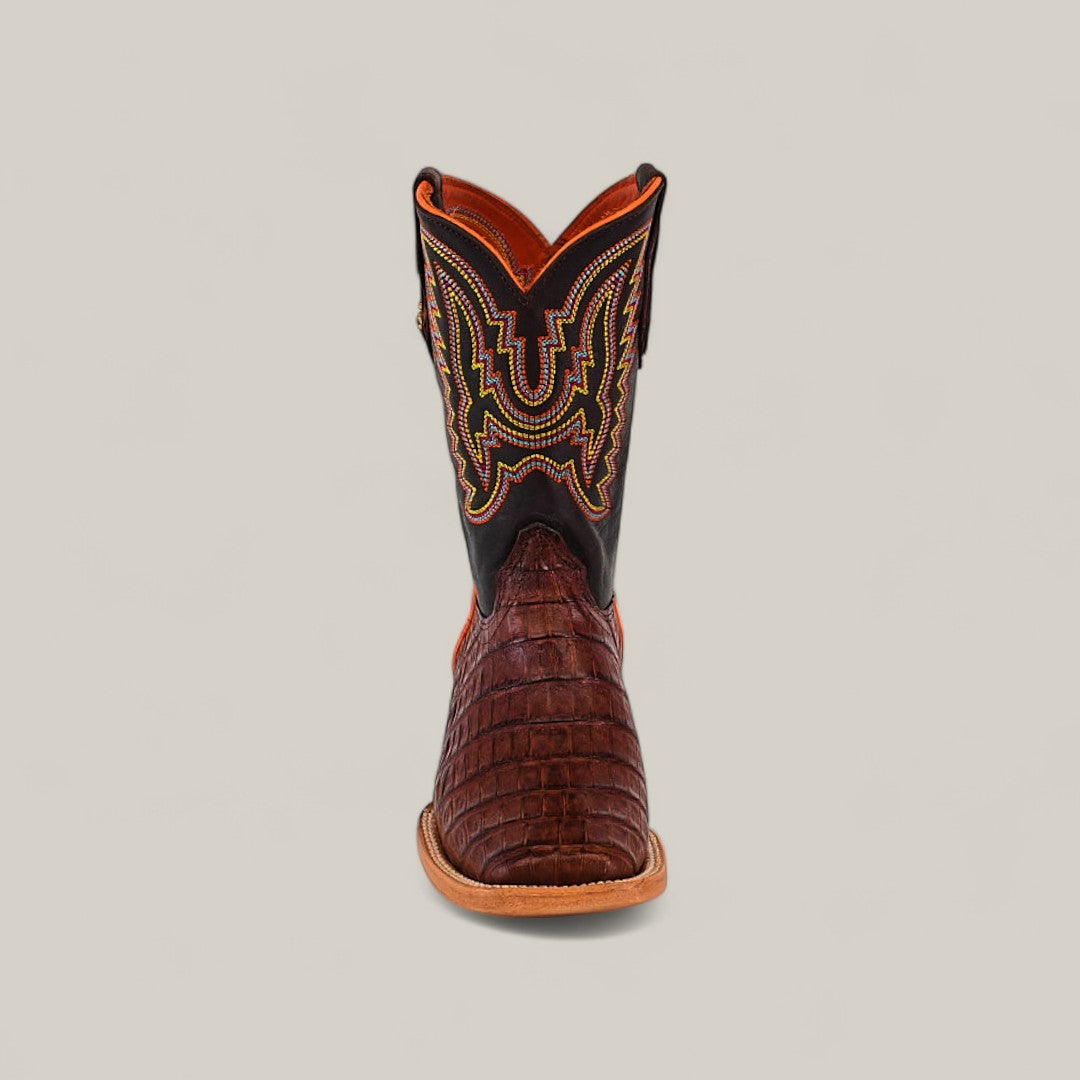 The Exotic Caiman Belly Tail Cognac - Square Toe Kids Boots feature a brown caiman-textured foot, a black shaft with orange and yellow stitching, and are shown front-facing on a plain light background.