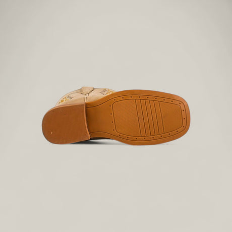 The Orion Suede Bone - Square Toe - Kids Boots feature a tan suede upper with subtle embroidery, a light brown rubber sole with tread patterns, and a slightly raised heel. Shown from the sole for detail.