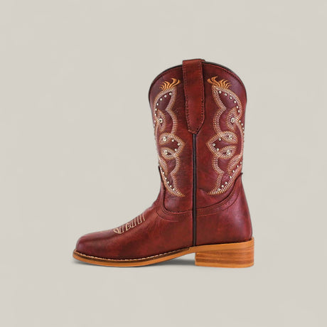 The Blake Cognac - Square Toe Kids Boot features rich brown leather, intricate light-colored stitching, and decorative shaft designs. It has a sturdy wooden heel and rounded toe, set against a plain light background.