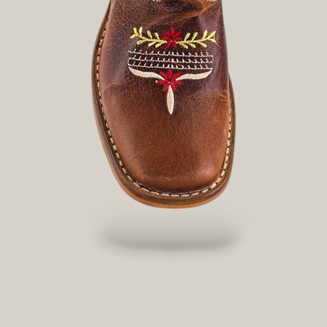 The Karo Brown - Square Toe - Kids Boot is displayed from above on a light gray background, featuring decorative red, yellow, and white toe stitching that enhances its classic design with comfort and elegance.