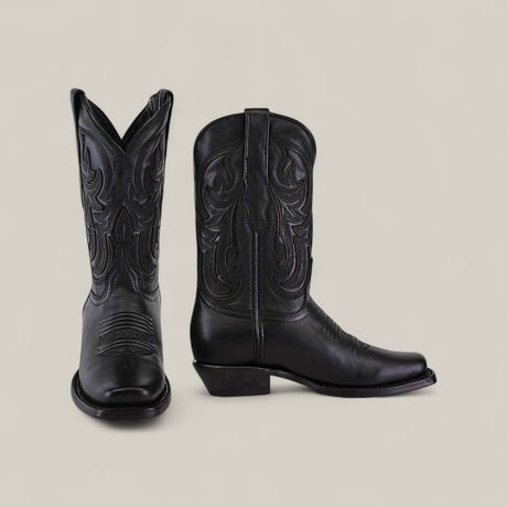 The Josie Full Black Short Shaft Narrow Square Toe womens cowboy boots, made of chic black leather with decorative stitching, are displayed against a plain light background—one boot facing forward, the other seen from the side.