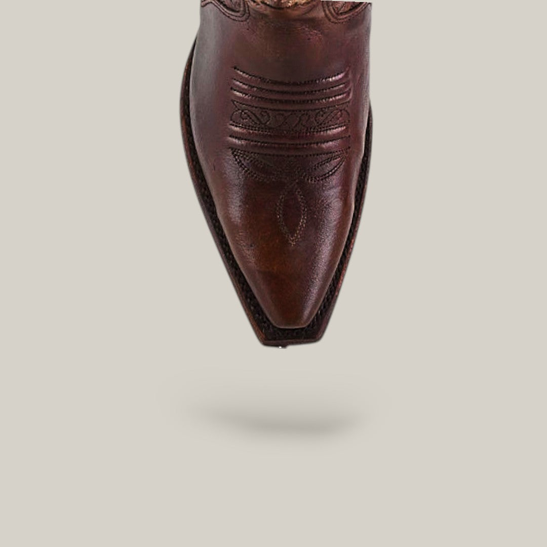 A close-up of the pointed toe on the Rachael Copper - Tall Shaft - Snip Toe boots showcases decorative stitching against a light background with a soft shadow. The perfect womens boots for standout Western style.