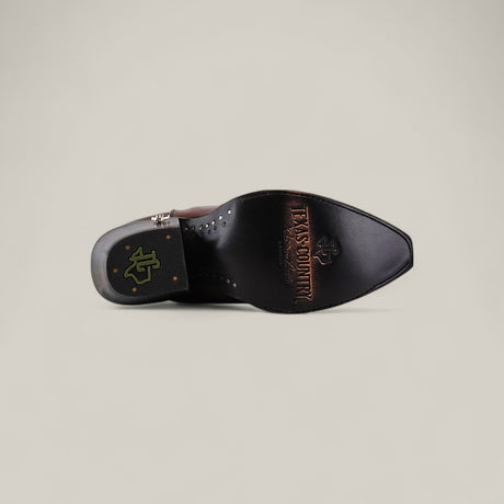 The Kellie Clayton Caramel Leather Sole boot features a tall shaft, snip toe, visible stitching, and is shown from the sole with TEXAS COUNTRY and a logo imprinted on the bottom.