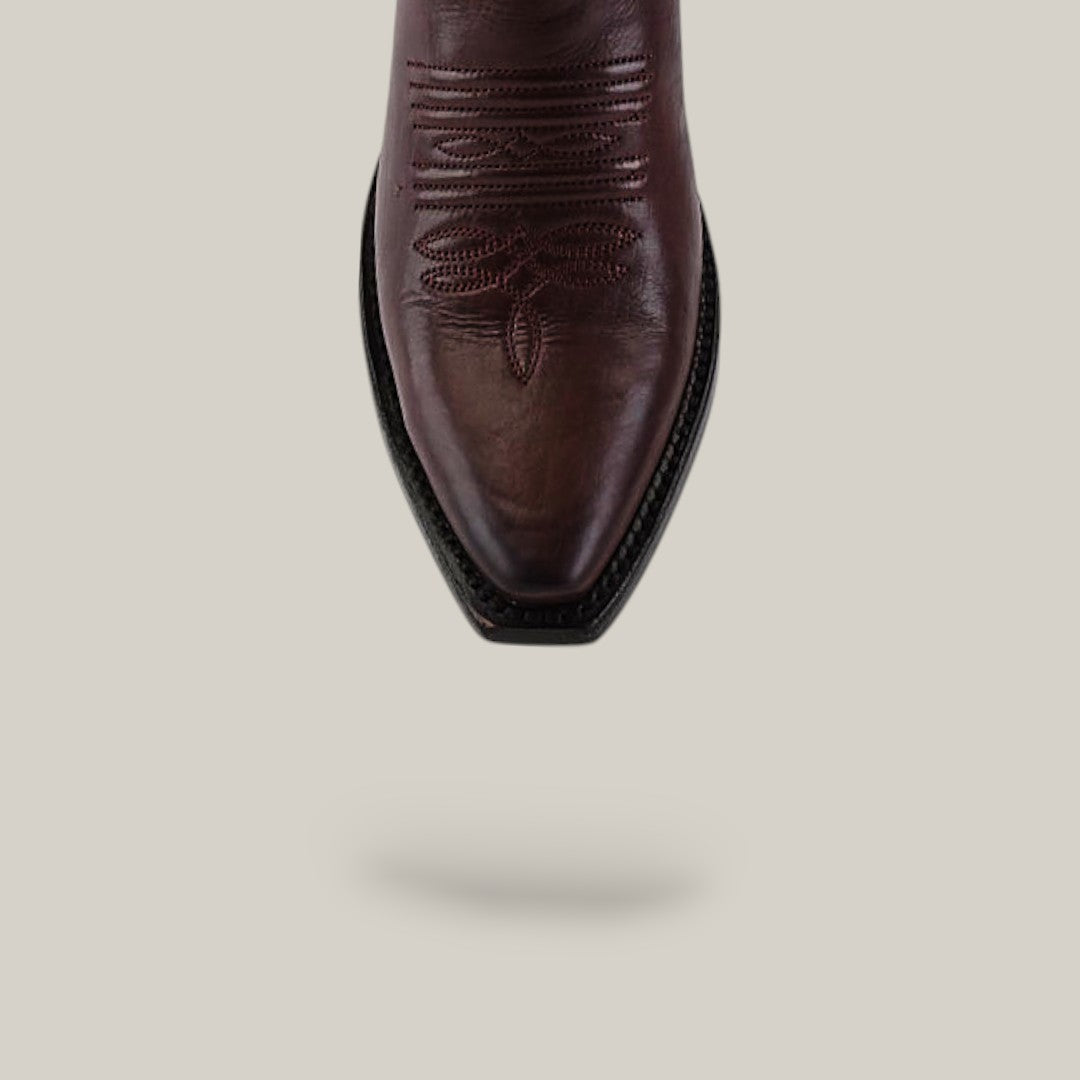 The Miranda Clayton Brownie Leather Sole boot features a brown leather snip toe and decorative stitching, shown from above on a beige background with a soft shadow. Its classic mid-shaft style and quality craftsmanship stand out.