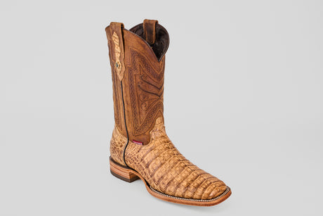 The Exotic Caiman Belly - Antique features tan caiman leather with intricate patterns, a square toe, stacked wooden heel, and decorative stitching on the upper shaft, all set against a plain gray background.