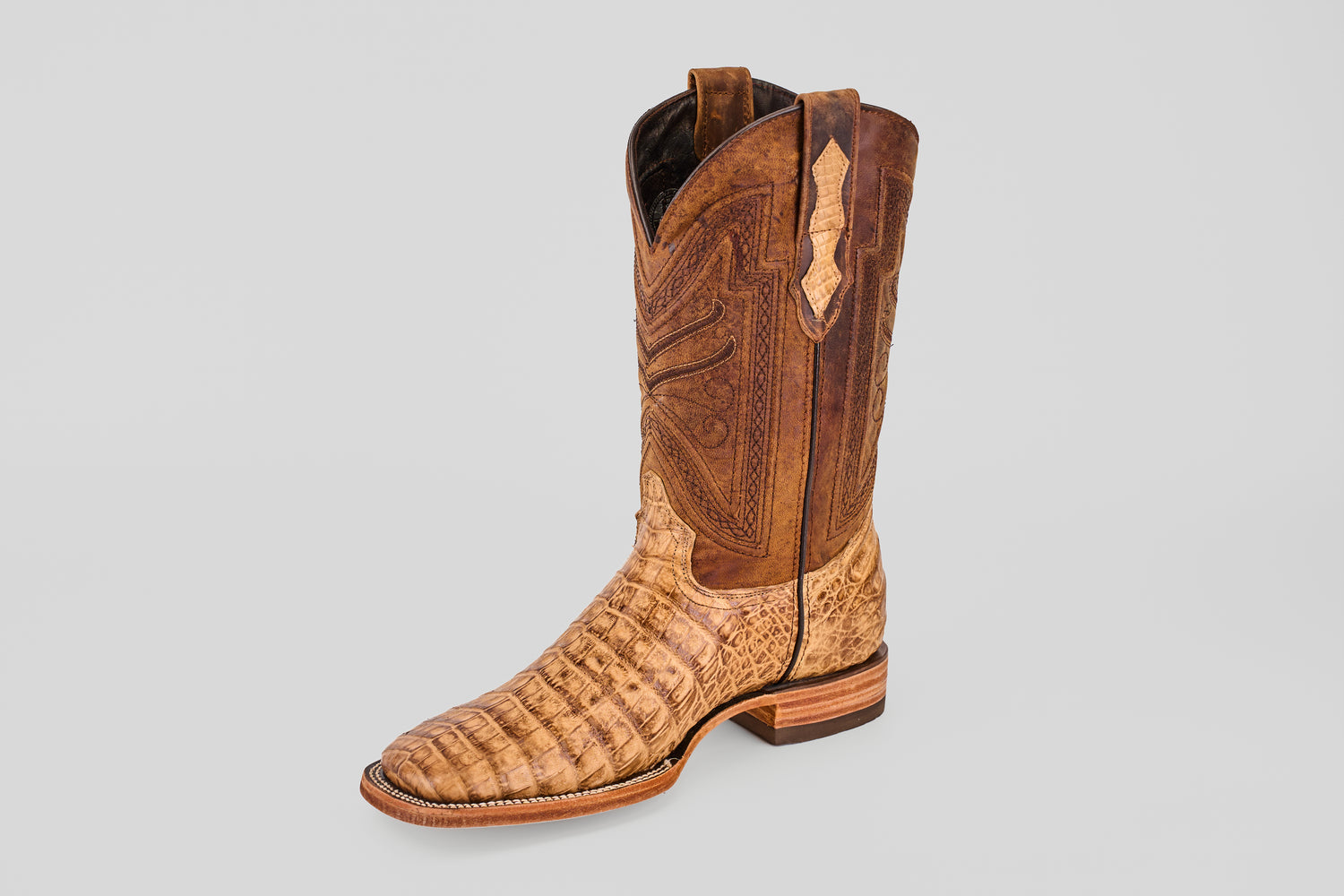 A single Exotic Caiman Belly - Antique - Square Toe boot featuring brown caiman leather with a textured, alligator-style pattern on the foot and detailed shaft stitching, displayed on a plain light gray background.
