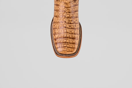 Close-up of the Exotic Caiman Belly - Antique - Square Toe boot’s toe, showcasing textured caiman leather with a crocodile pattern and detailed edge stitching, set against a light gray background.