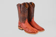The Exotic Caiman Horn Back - Brandy - Square Toe boots feature textured reddish-brown leather on the vamp and dark brown stitched leather shafts, shown upright against a light gray background.