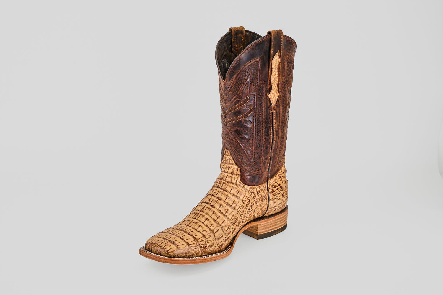 The Exotic Caiman Horn Back - Antique - Square Toe boot features a tan, textured caiman-style lower and a darker brown stitched upper shaft, all showcased against a plain light gray background.