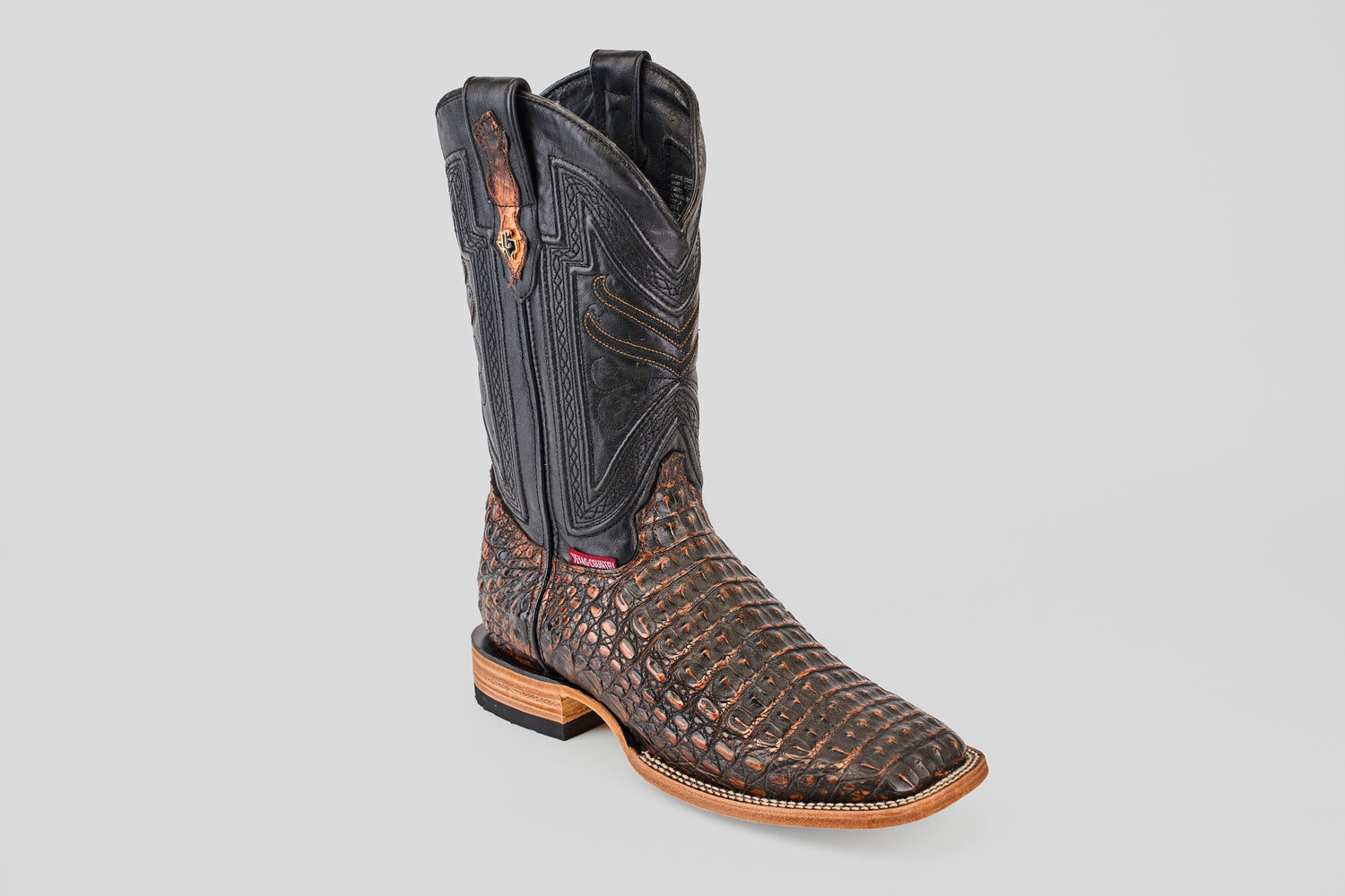 The Exotic Caiman Horn Back - Roma - Square Toe boot features a dark brown textured leather lower and black stitched upper, with a wooden heel, displayed on a light gray background—a modern spin on classic western boots.