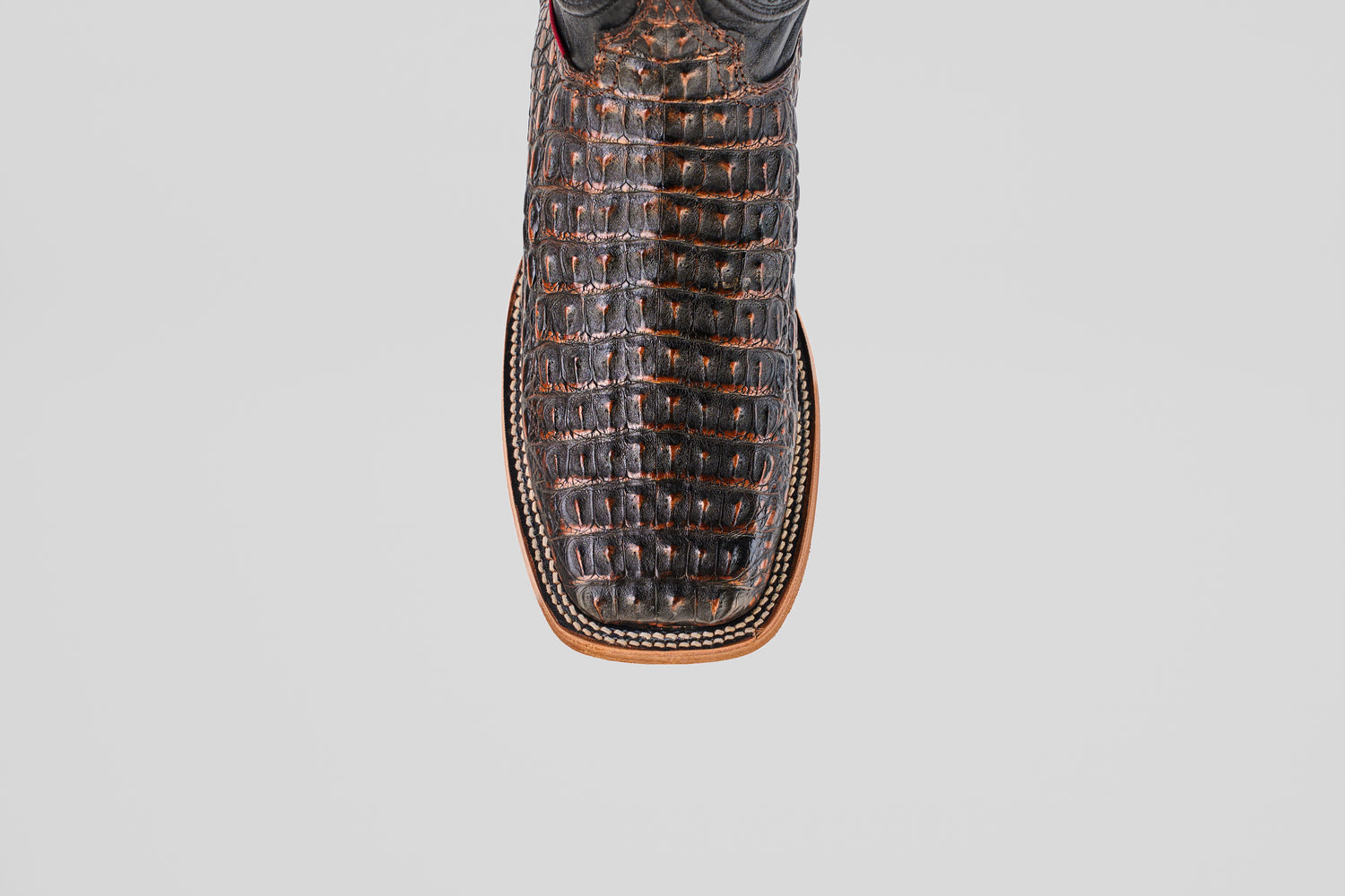 Close-up top view of the Exotic Caiman Horn Back - Roma boot, featuring brown textured caiman leather, a square toe, and detailed edge stitching, set against a plain white background.