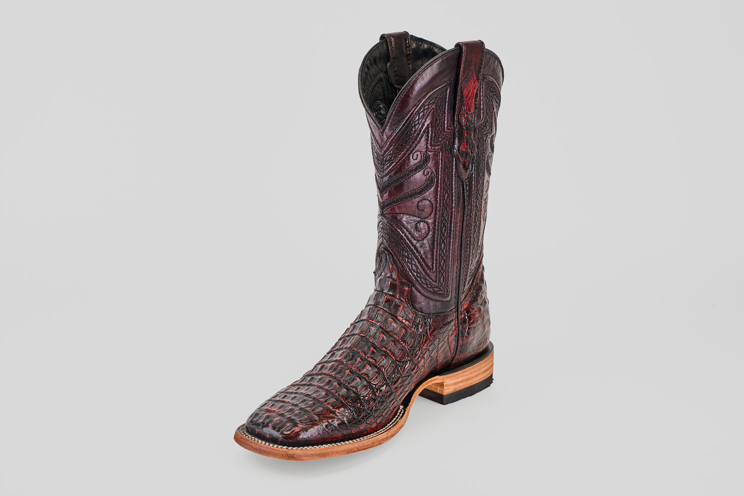 A single Exotic Caiman Horn Back - Black Cherry - Square Toe boot, featuring intricate stitching and a textured reptile pattern, is displayed on a light gray background.