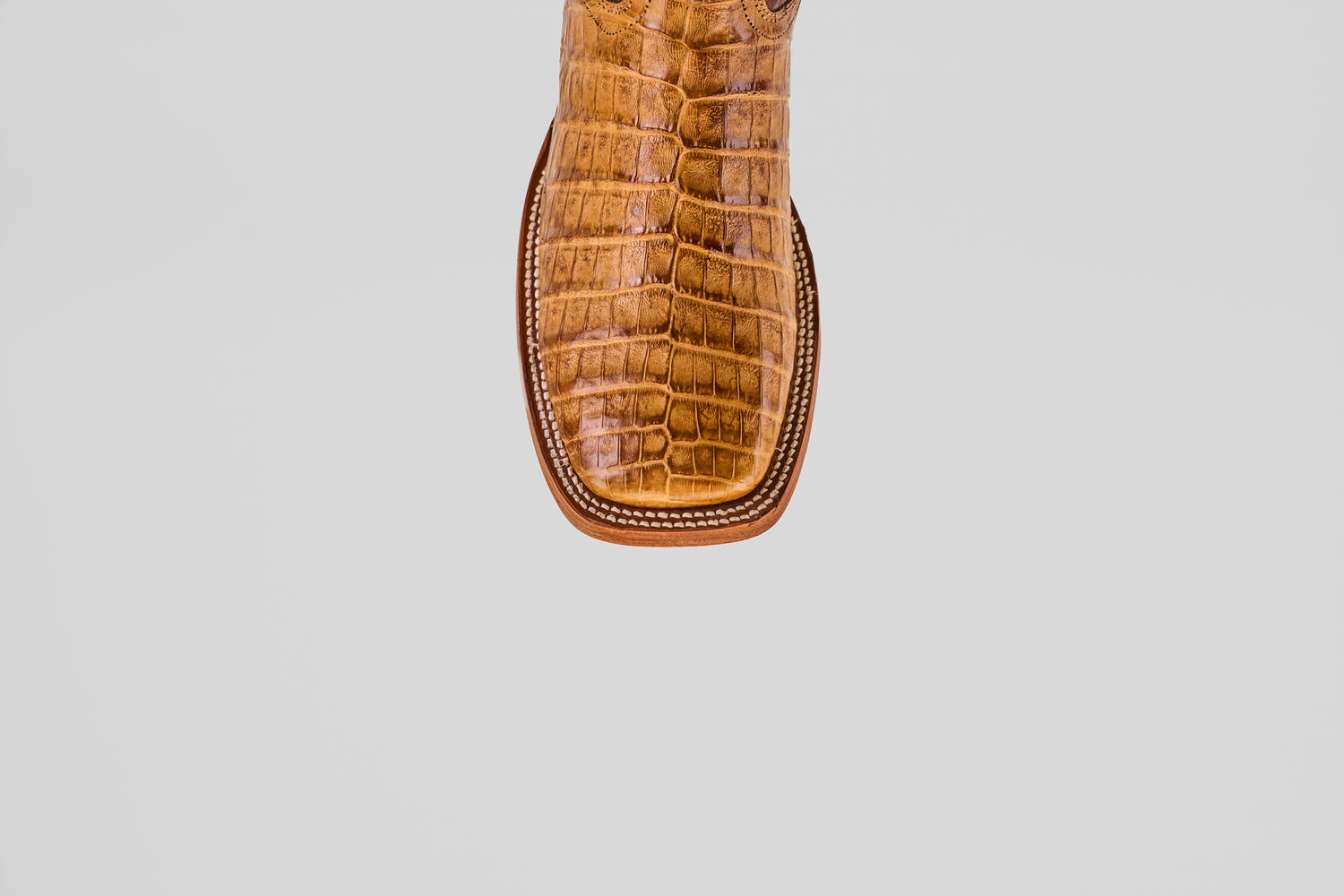 A close-up of the Exotic Caiman Belly - Camel - Square Toe boot shows its brown caiman leather with a textured, crocodile-like pattern and square tip, set against a plain white background.