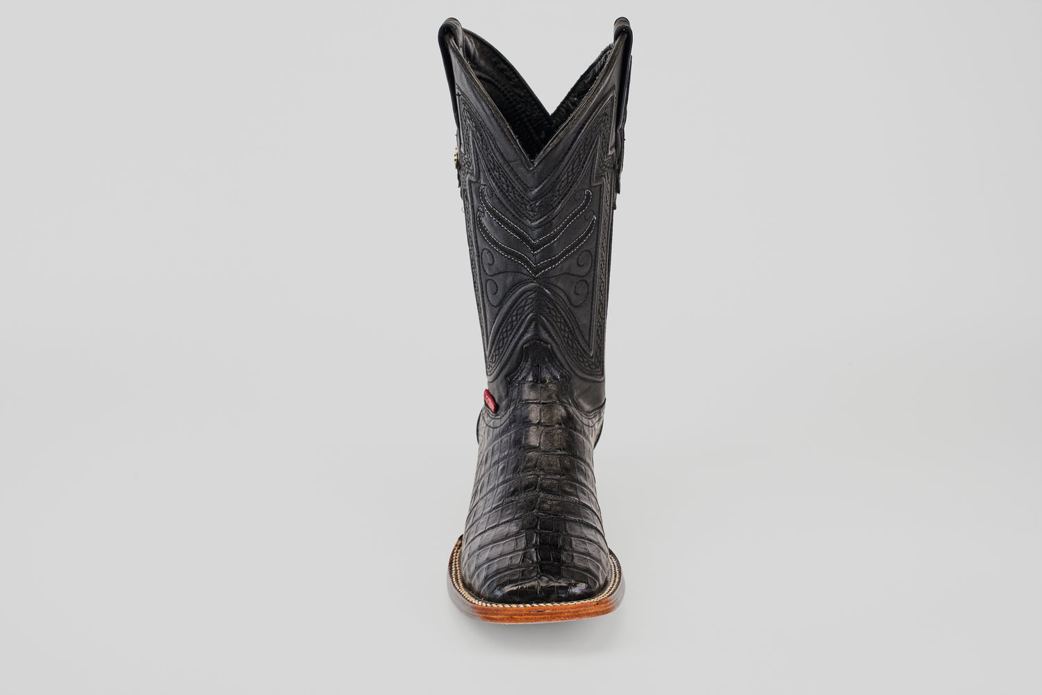 The Exotic Caiman Belly - Black- Square Toe boot, crafted from caiman leather with detailed stitching and a textured pattern, is displayed from the front against a plain light gray background.
