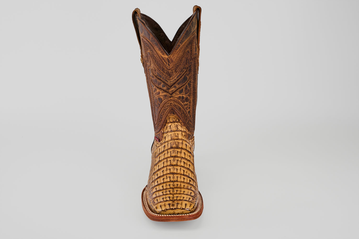 The Exotic Caiman Horn Back - Biza Camel - Square Toe boot features an intricate brown leather upper and a textured, light tan lower section, displayed against a plain light gray background.