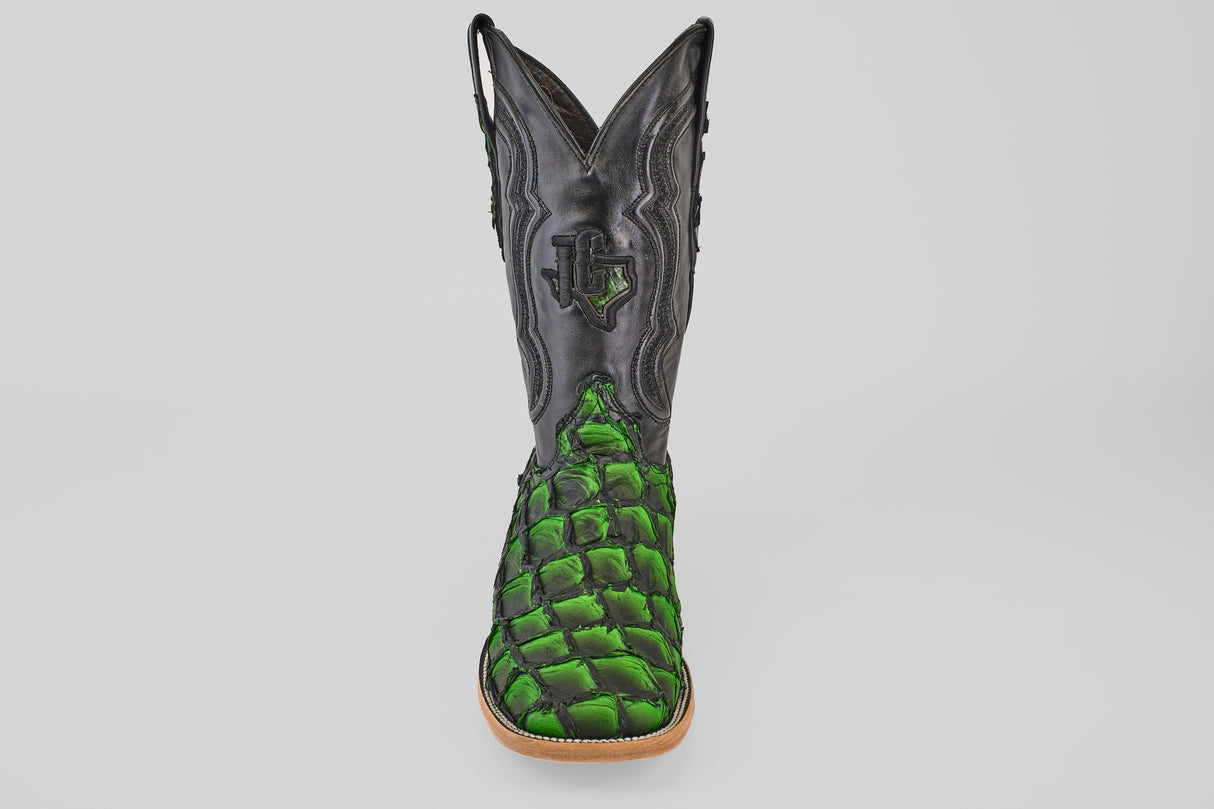 A striking Conor - Swamp Green - Square Toe boot, featuring a black upper and vivid green, scale-textured lower section, is showcased front-facing against a light background—an eye-catching Pirarucu fish leather design.