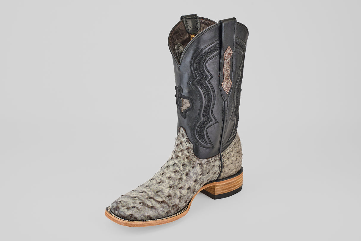 The Exotic Full Quilt Ostrich - Nicotine - Square Toe mens boot features a textured light gray ostrich lower, black stitched upper shaft, wooden heel, and square toe, shown individually on a plain white background.
