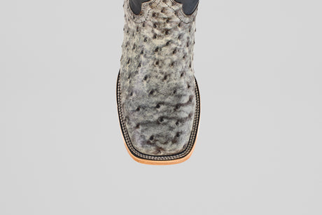 A close-up, top-down view of the Exotic Full Quilt Ostrich - Nicotine - Square Toe boot in textured gray ostrich leather with black speckles and a tan-and-black stitched sole, showcasing its expert craftsmanship.