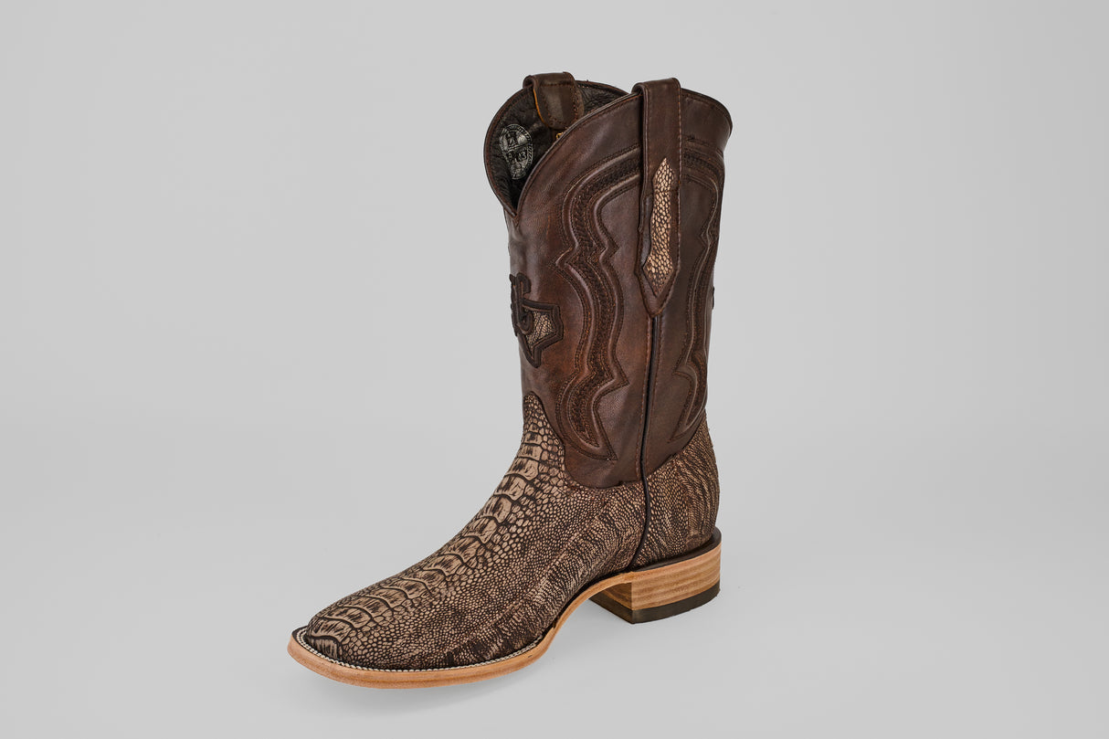 The Exotic Full Quilt Ostrich Leg - Matte Orix - Square Toe boot, featuring a dark brown leather upper, light brown textured lower, wooden sole, and low heel, is shown on a plain light gray background.