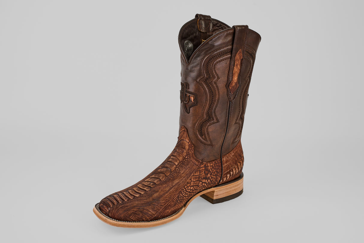 A single Exotic Full Quilt Ostrich Leg cowboy boot in Rustic Brick with a square toe, detailed stitching, and embossed patterns on the shaft and foot, displayed against a plain light gray background.