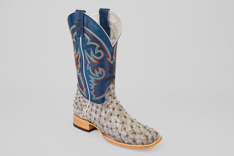 The Russell - Rustic Gray - Square Toe boot features textured light gray ostrich leather, a tall blue shaft with colorful embroidery, and a wooden sole for classic Western style.