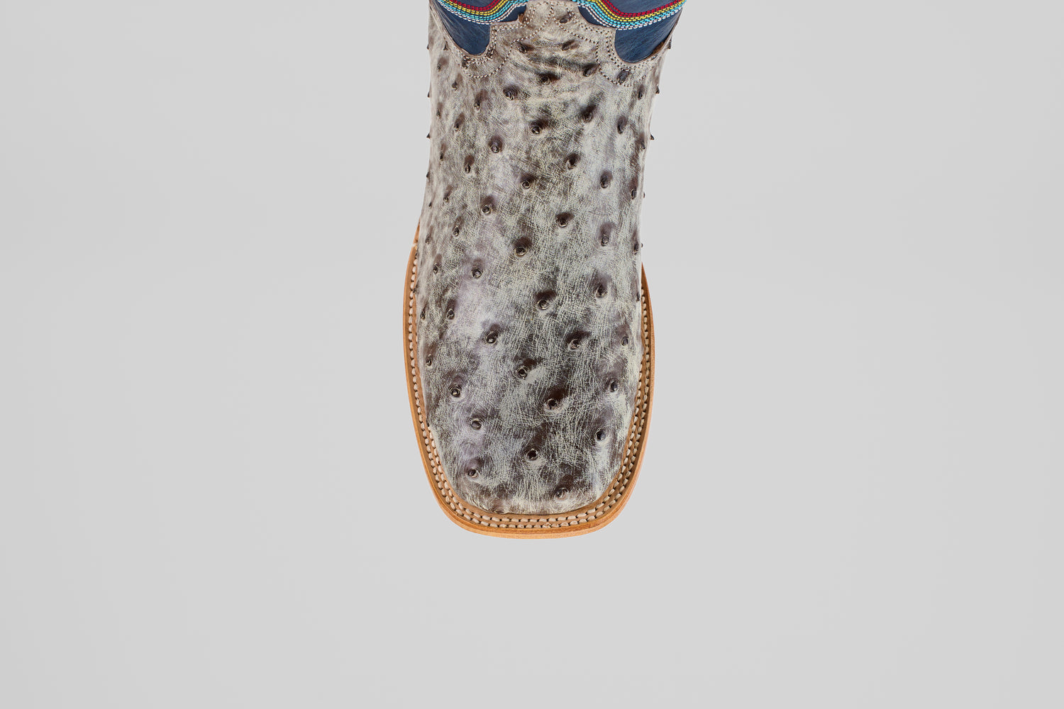 A top-down view of the Russell - Rustic Gray - Square Toe boot, featuring a textured, spotted gray surface, square toe, and tan stitching.