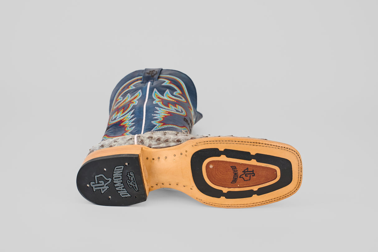 A single Russell - Rustic Gray - Square Toe cowboy boot lies on its side, showing the decorative gray upper, tan leather sole, and black Durango logo—an eye-catching example of Western style boots.