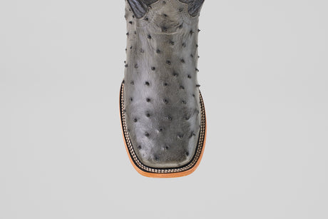 A close-up of the Exotic Full Quilt Ostrich - Gray - Square Toe boot, showing its gray full quilt ostrich leather, square tip, and decorative stitching along the sole's edge.