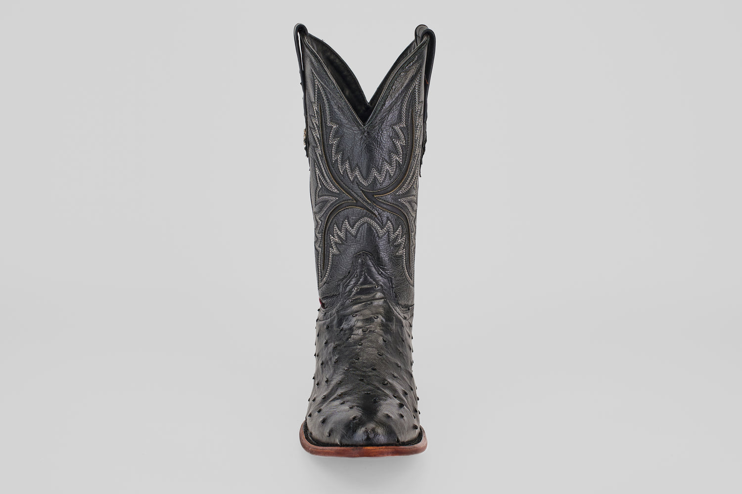 The Exotic Full Quilt Ostrich - Black - Round Toe boot features decorative stitching and classic Western style, displayed front-facing against a plain light gray background.