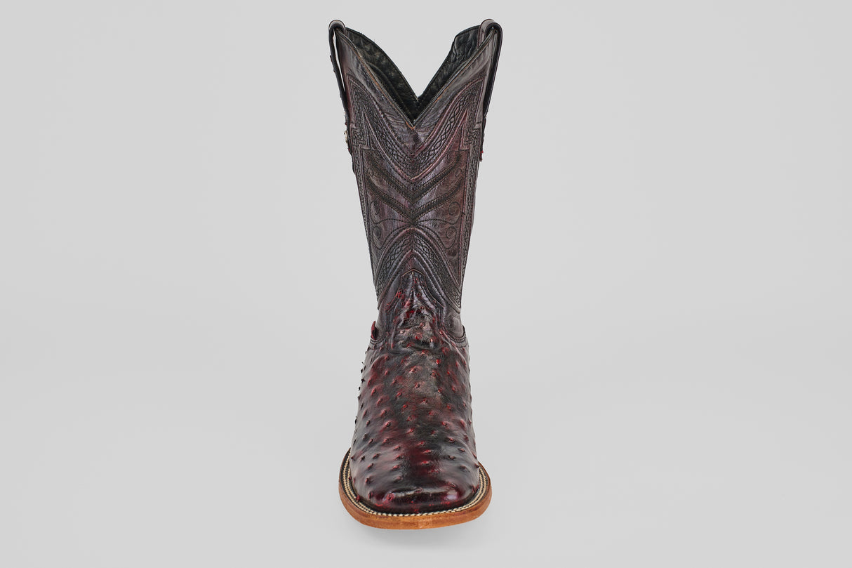 A single Exotic Full Quilt Ostrich boot in Black Cherry with a square toe, featuring decorative stitching and a textured pattern, handcrafted and photographed from the front against a plain light gray background.
