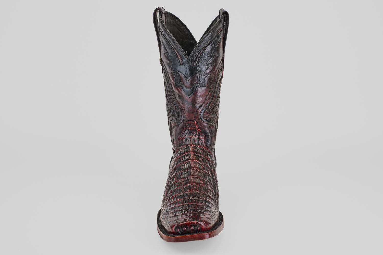 The Exotic Caiman Hornback - Blackcherry - Rodeo Toe boot, featuring a pointed toe, crocodile texture, and decorative stitching, stands upright against a plain light background.