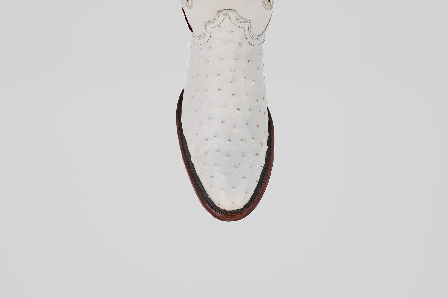 A top-down view of a single Austin - White - Round Toe ostrich leather cowboy boot with a round toe and dark brown sole, set against a plain light background.